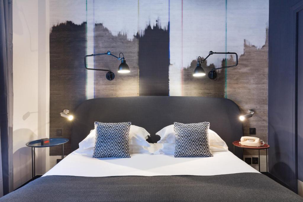 una camera con un letto con due cuscini blu e bianchi di Hotel So’Co by Happyculture a Nizza