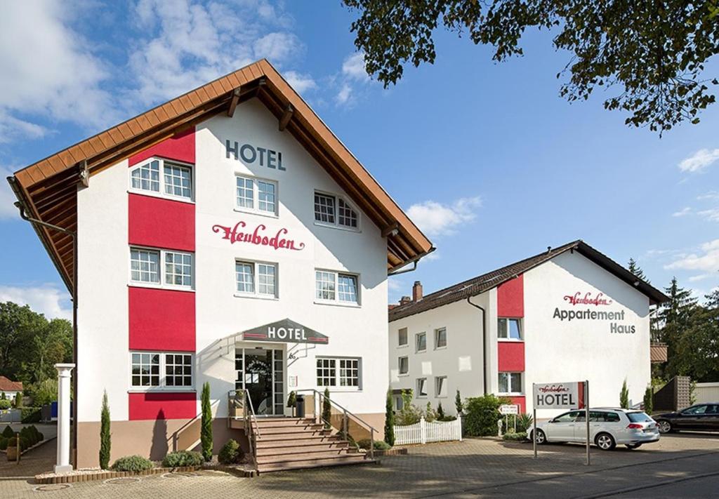 ein Hotel mit einem roten und weißen Gebäude in der Unterkunft Hotel Heuboden in Umkirch