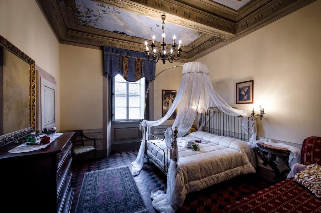 a bedroom with a bed with a canopy at Palazzo Petrella in Cortona