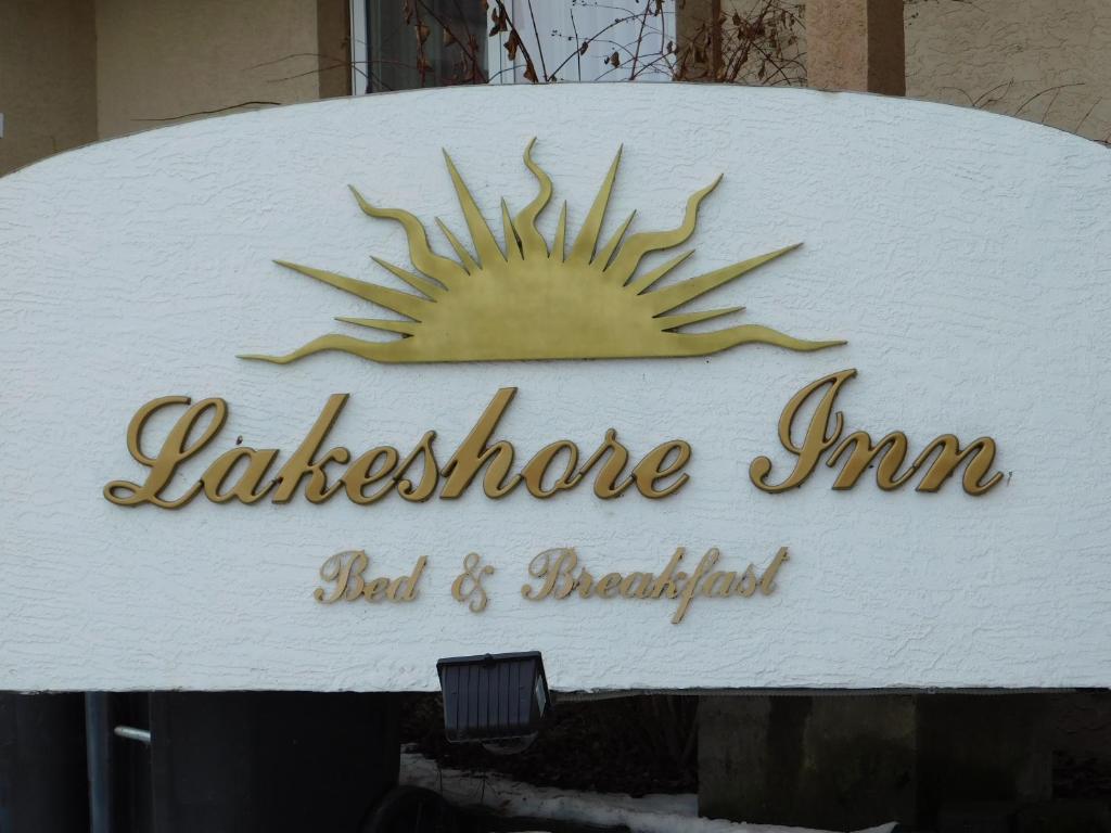 um sinal para uma loja com um sol sobre ele em Lakeshore Inn em Cold Lake