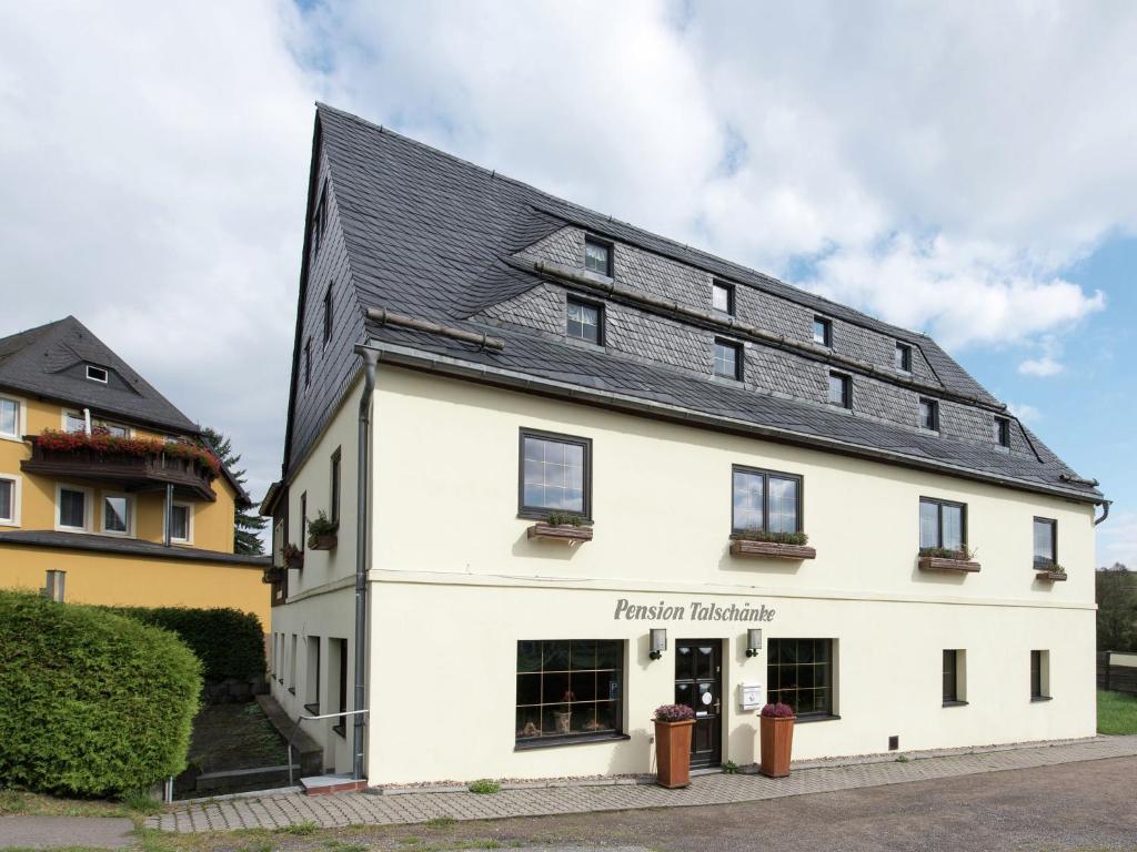 um edifício branco com um telhado preto em Spacious holiday home in the Ore Mountains em Deutschneudorf