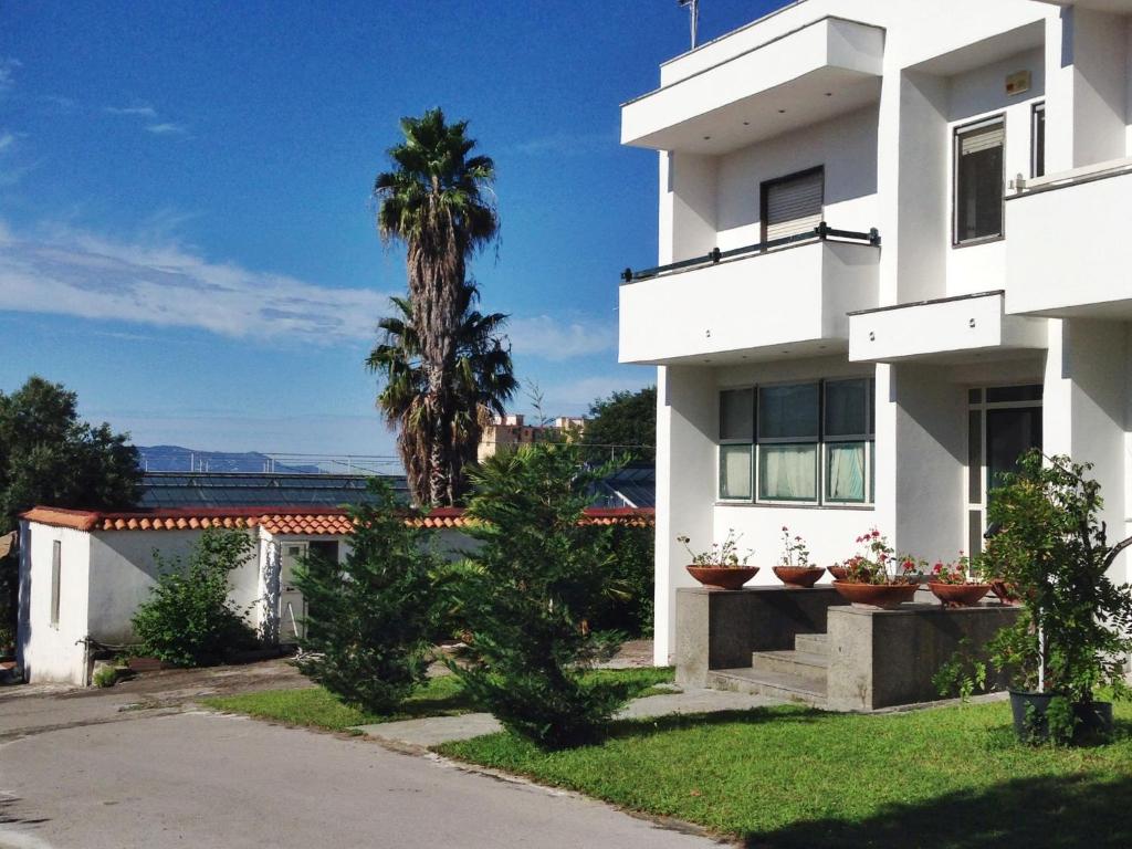 ein weißes Gebäude mit einer Palme im Hintergrund in der Unterkunft Modern Apartment in Trecase with garden in Trecase