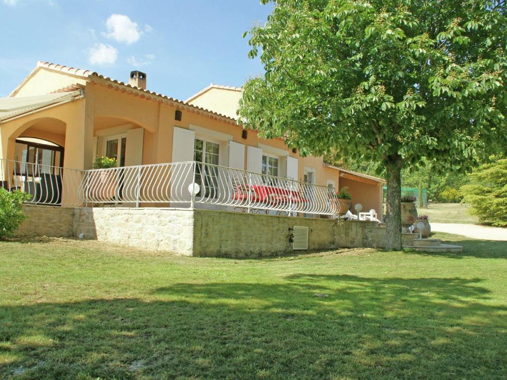 a house with a deck on the side of a yard at Detached villa with enclosed beautiful garden and private pool 1km from C reste in Reillanne
