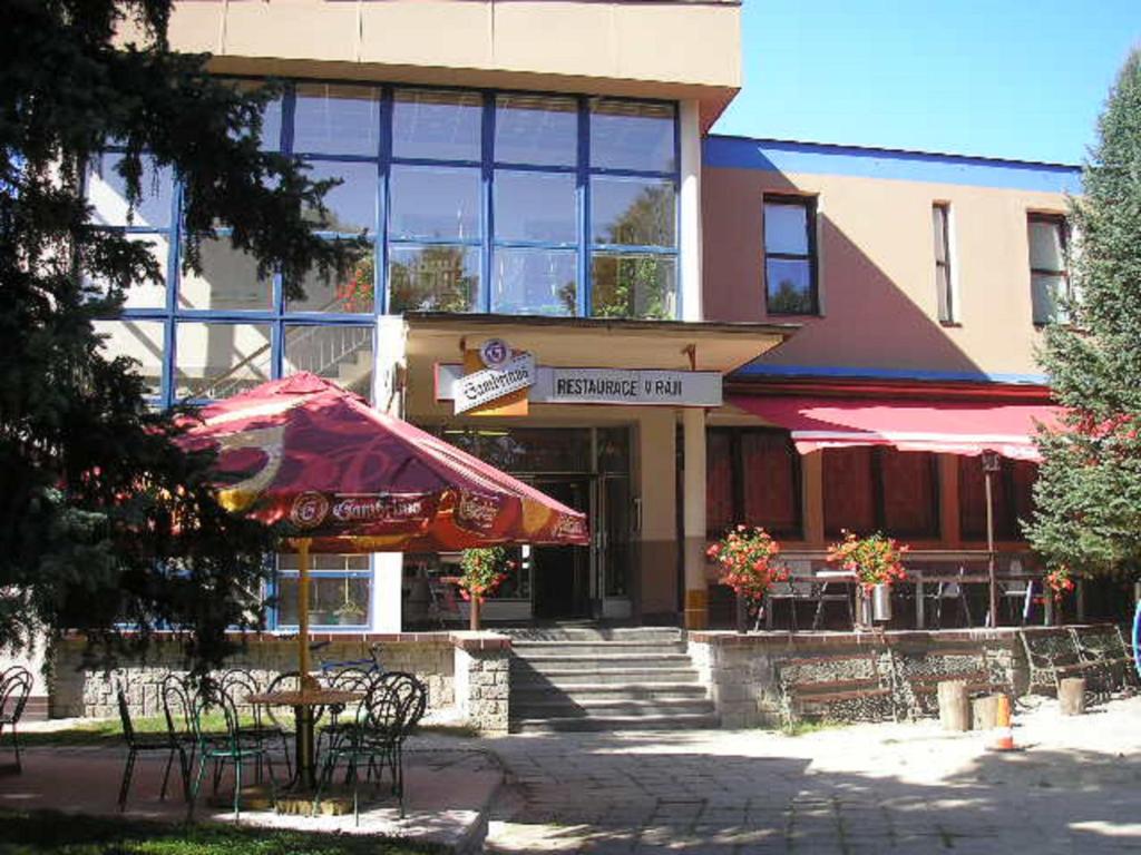 un edificio con un tavolo e un ombrello davanti di Penzion V Ráji a Strakonice