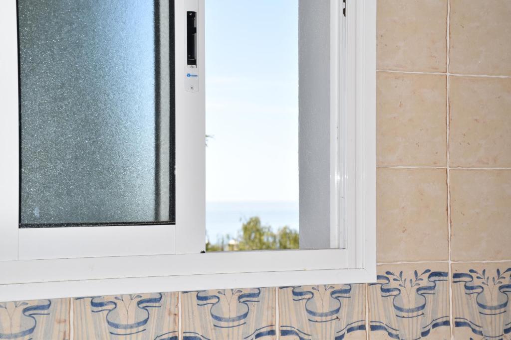 Una ventana en un baño con suelo de baldosas. en Villa Pelae, en Frigiliana