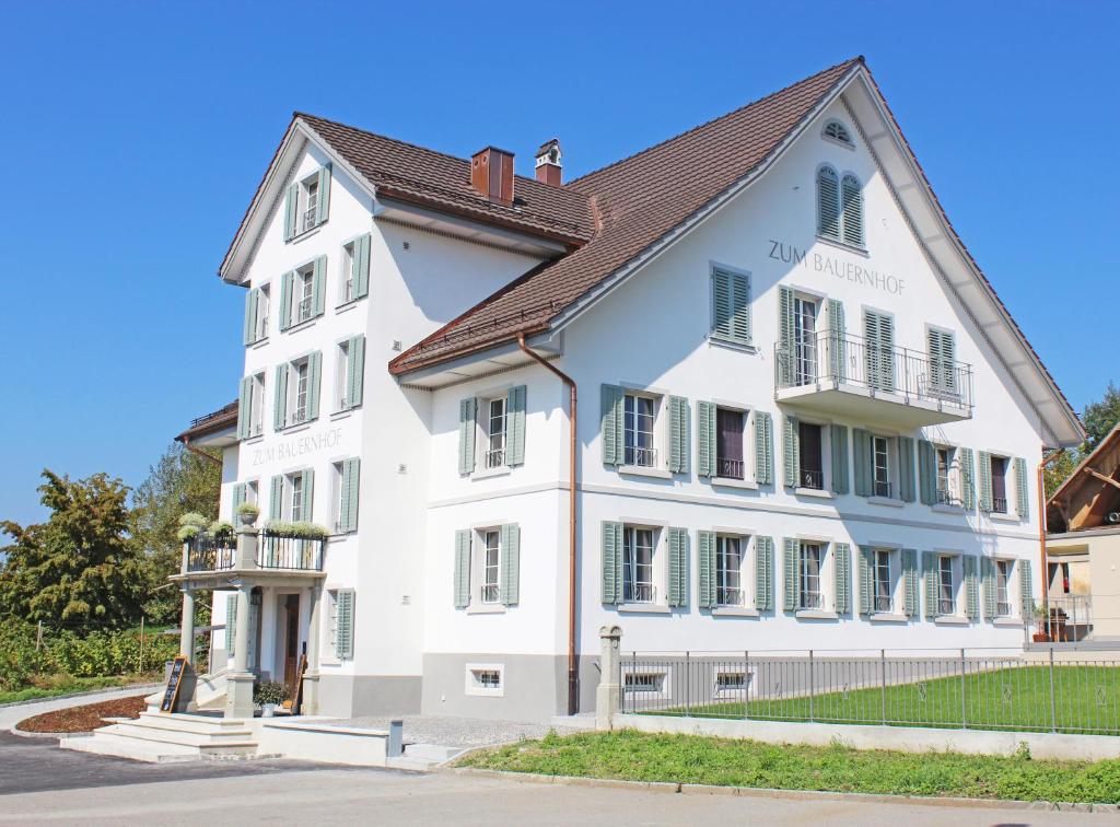 un edificio bianco con tetto marrone di Gasthaus zum Bauernhof a Oberlunkhofen