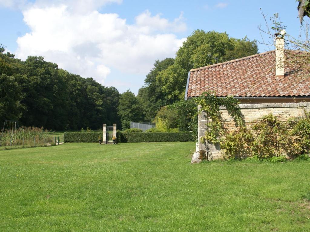 an old building in a grassy field next to a cemetery at Superb villa with private heated pool in Revigny-sur-Ornain