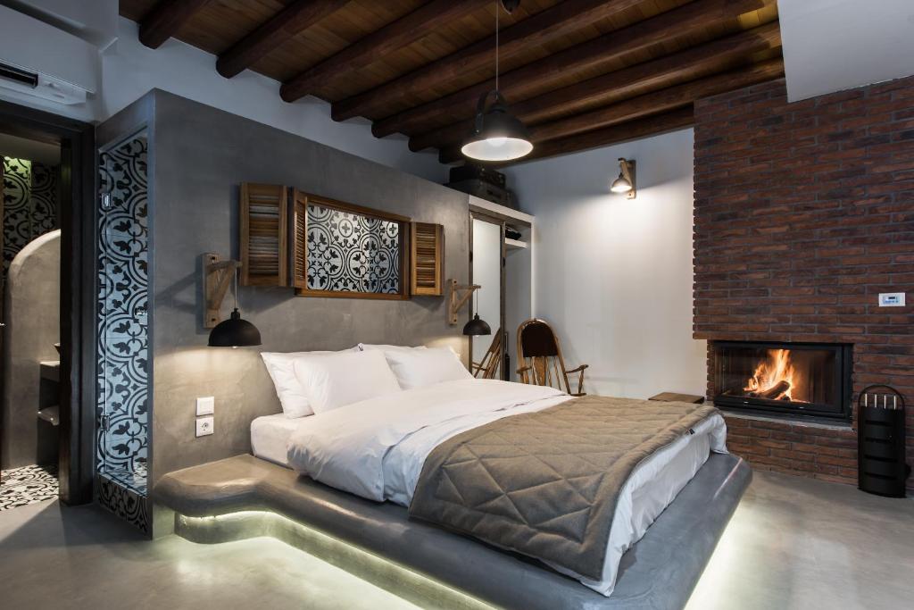 1 dormitorio con 1 cama grande y chimenea en Olganos VL Luxury Rooms & Suites, en Veria