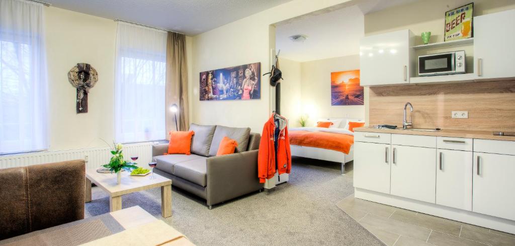 sala de estar con sofá y cama en Weyher Aparthotel, en Weyhe