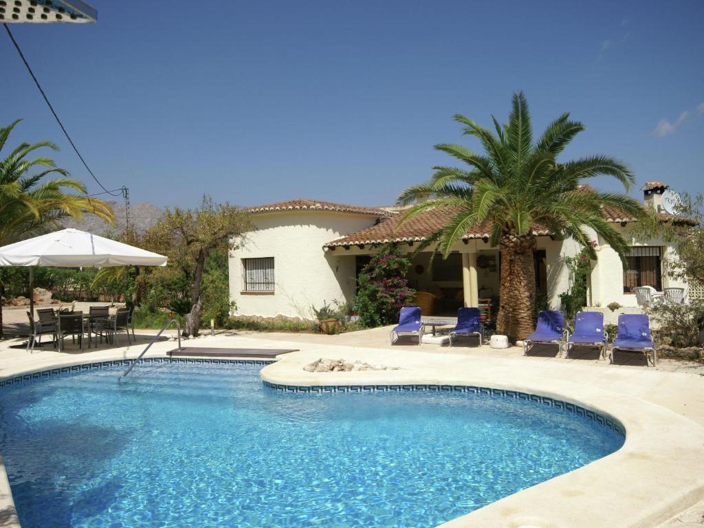 una piscina con sedie blu e una casa di Belvilla by OYO Casa Smit a Parcent