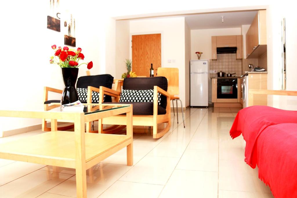 Il comprend un salon avec une table et des chaises ainsi qu'une cuisine. dans l'établissement Photothea Apartments, à Protaras