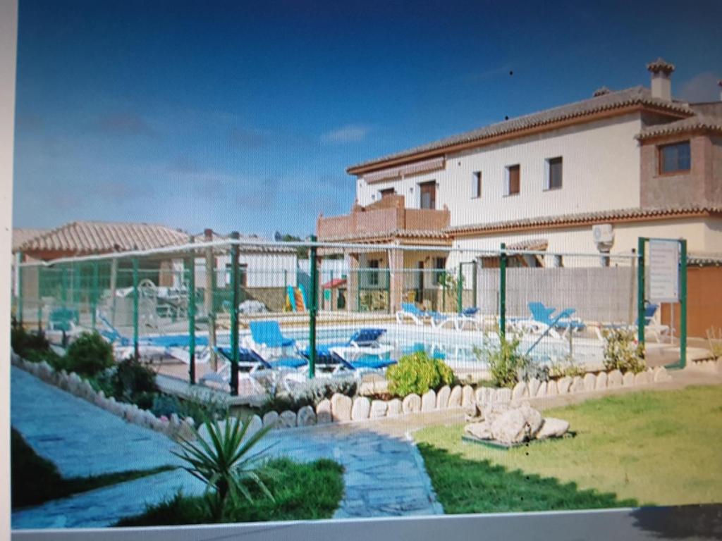 a resort with a swimming pool and a building at Residencial La Teja in Zahora