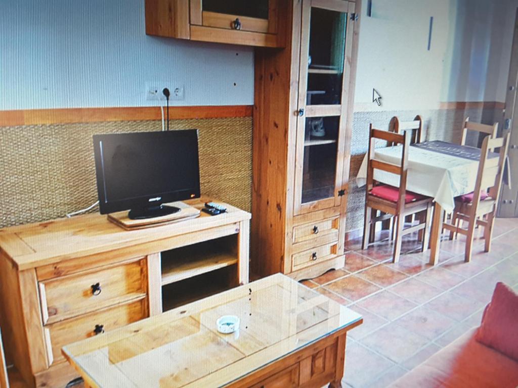 a living room with a tv on a wooden table at Residencial La Teja in Zahora