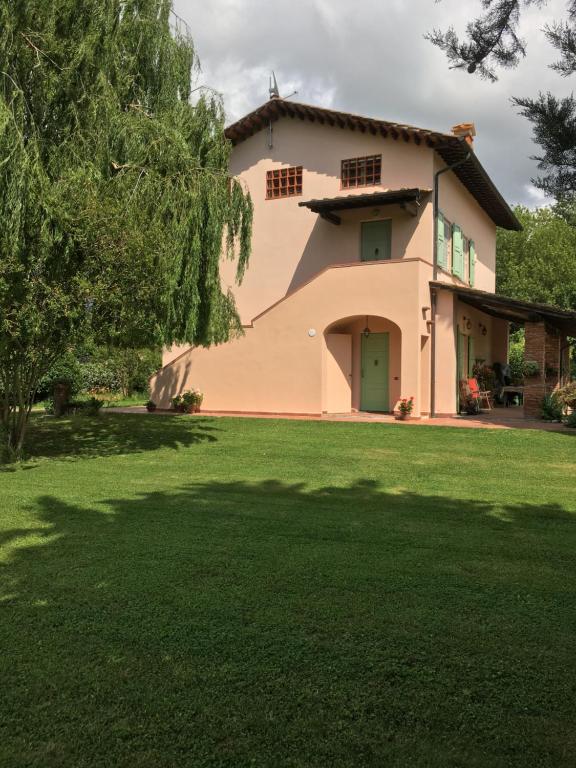 a house with a green lawn in front of it at Villa Favilli in Pisa
