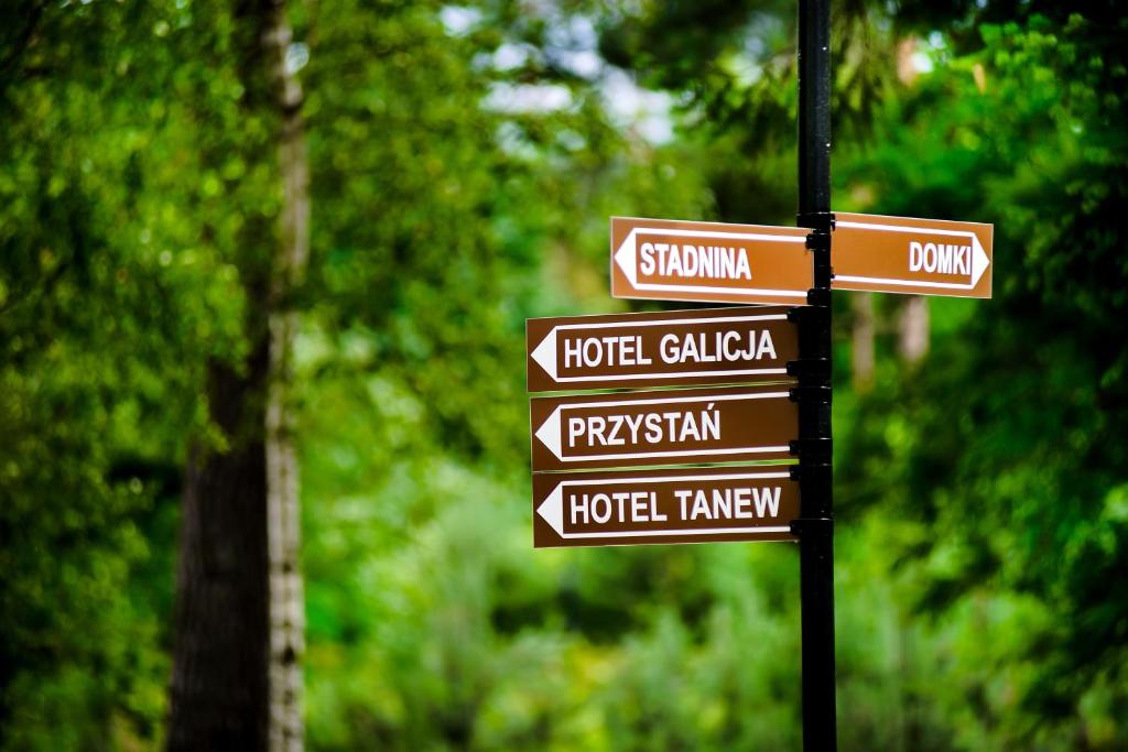 a pole with street signs in a park at Hotel Galicja in Ulanów
