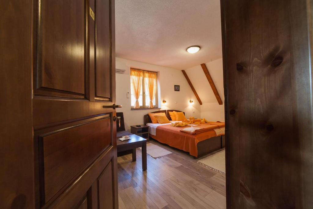 a bedroom with a bed and a room with a door at Guest House Rustico in Korenica