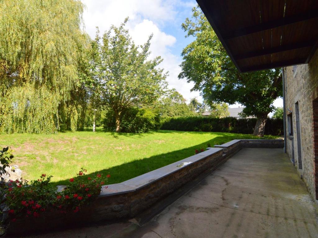 un jardín con césped y árboles y un edificio en Inviting Holiday Home in Beauraing, en Honnay