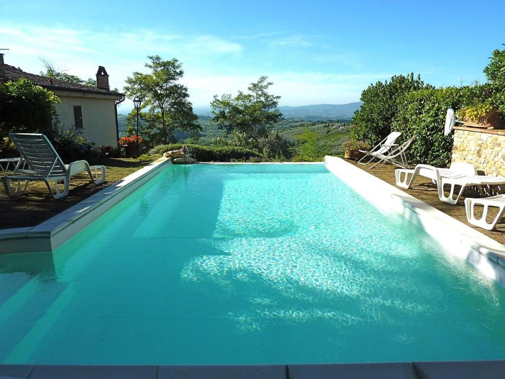 タヴァルネッレ・ヴァル・ディ・ペーザにあるLush Holiday Home in Tavarnelle Val di Pesa with Shared Poolの青いスイミングプール(椅子、テーブル付)