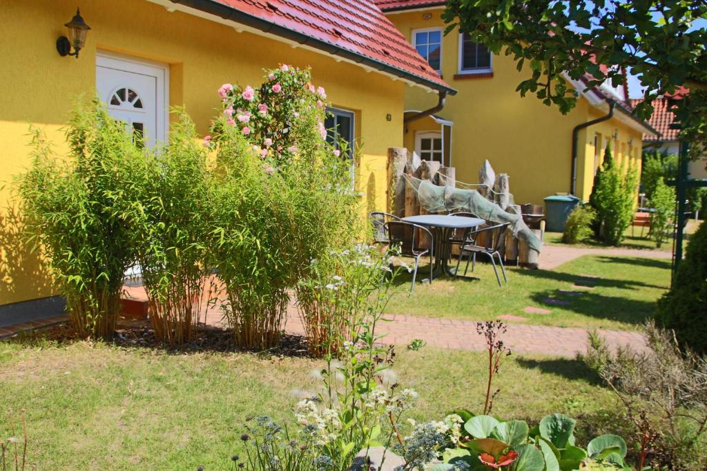 a garden with a table and chairs in front of a house at Ferienwohnungen Thorsten Fründt in Prerow
