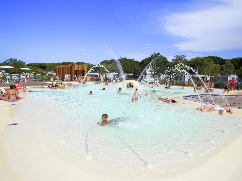 un gruppo di persone che nuotano in un parco acquatico di Nice chalet in a pine forest near the Adriatic sea a Cesenatico
