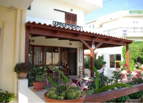 a building with a patio with plants in front of it at Pension Kyriakos in Plakias