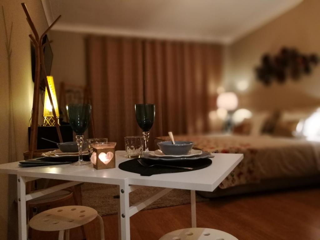 a white table with two plates and wine glasses at Pontocom Bolhão Apartment in Porto