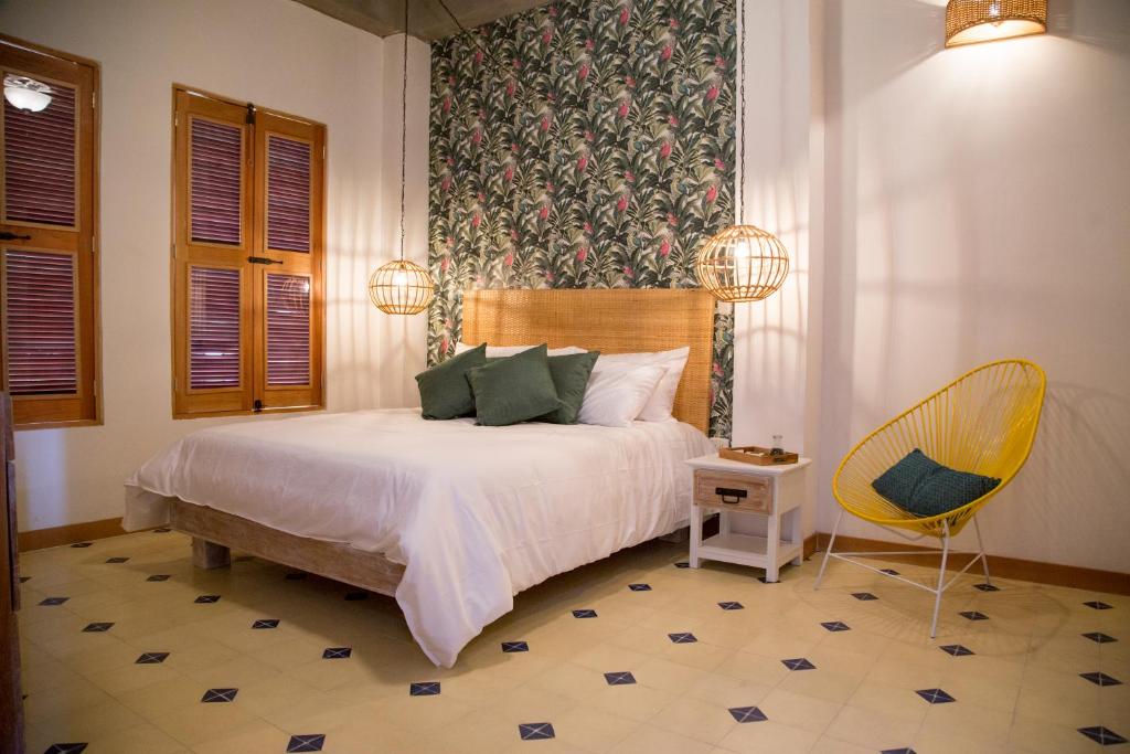 - une chambre avec un lit et une chaise dans l'établissement Hotel Boutique Casa Mia, à Santa Marta