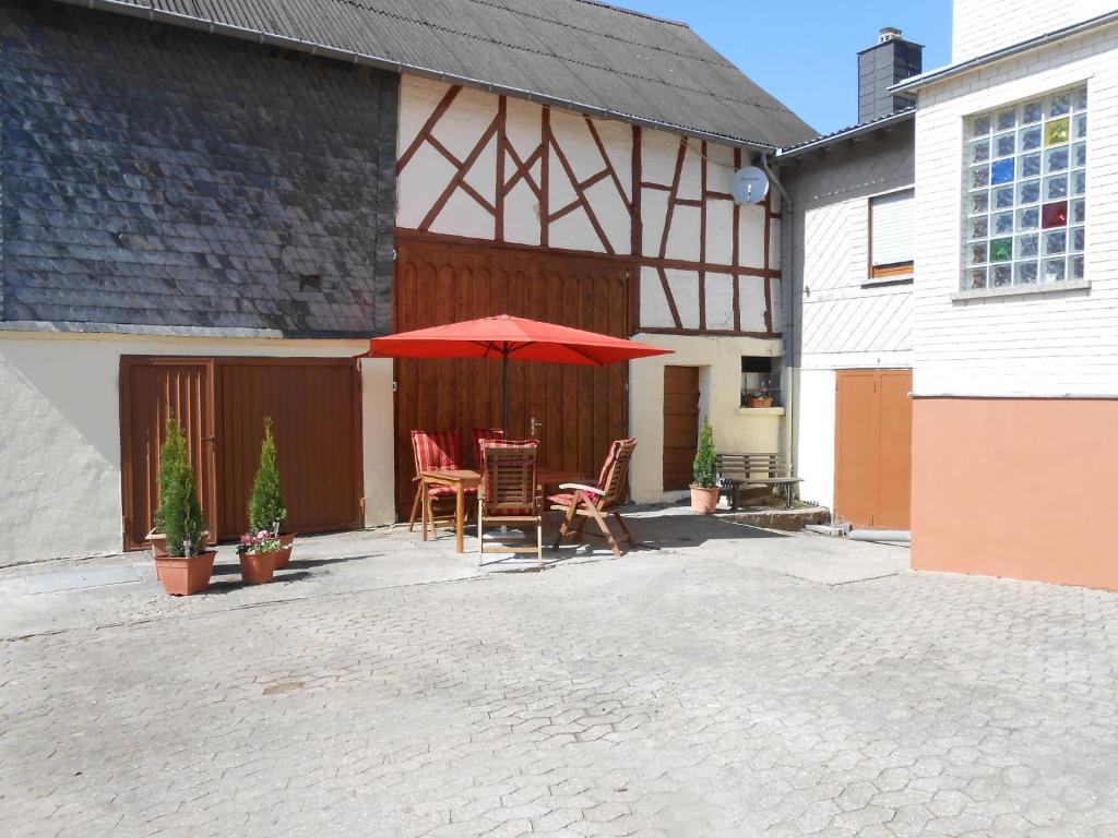 a patio with chairs and an umbrella in front of a building at Holiday home in Haserich with terrace in Haserich