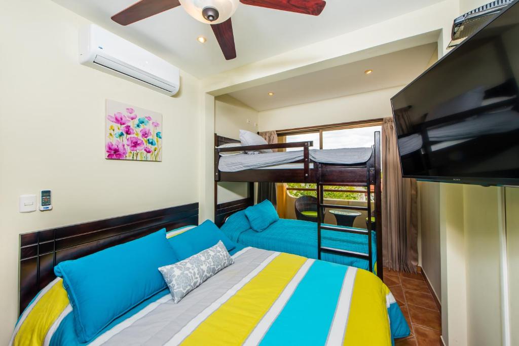 a bedroom with a bed and two bunk beds at Coco Sunset Hills #52 in Coco