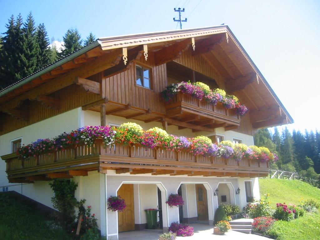 una casa con un balcón con flores. en Oberegghof, en Wagrain