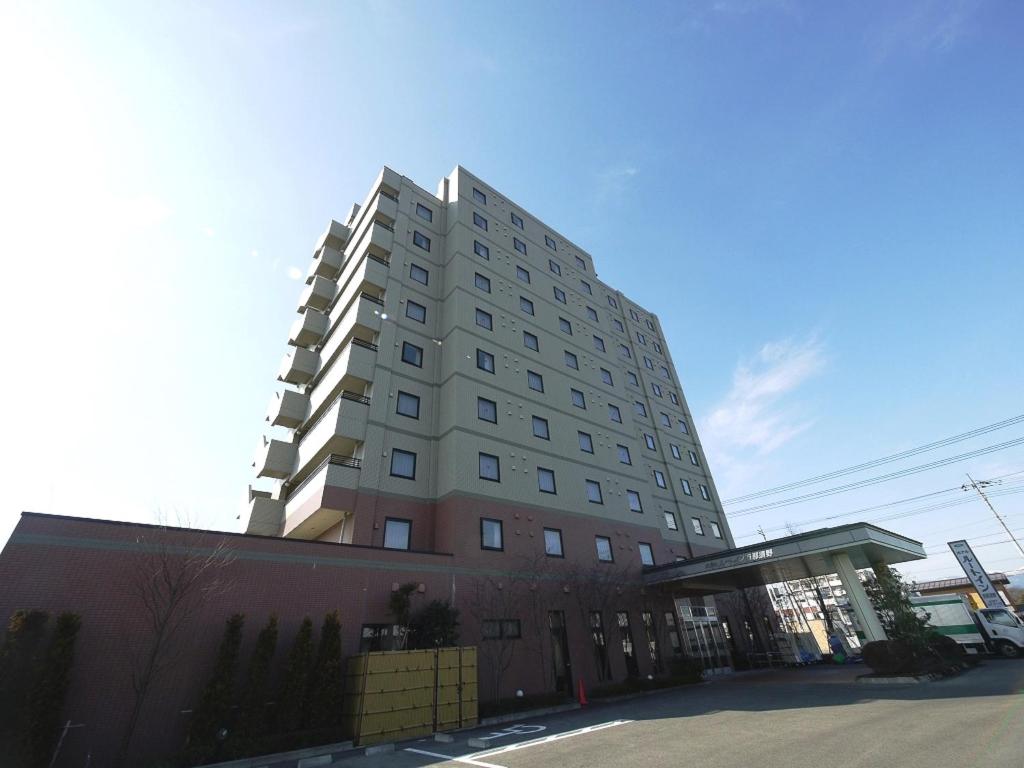 un edificio blanco alto al lado de una calle en Hotel Route-Inn Nishinasuno, en Nasushiobara