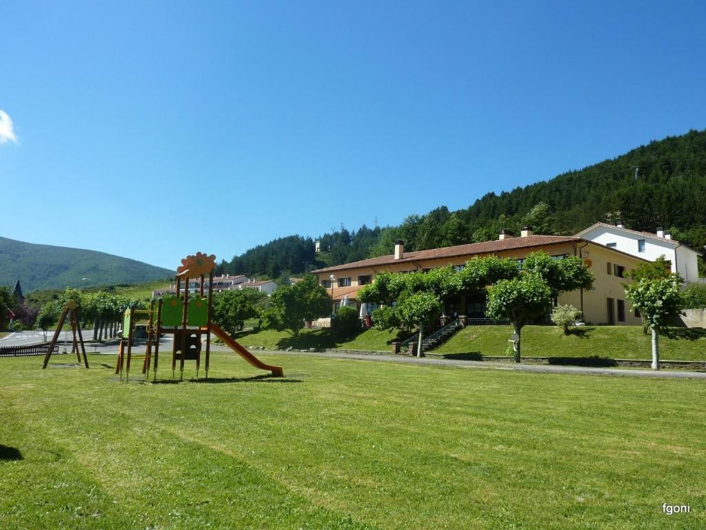 un parque con columpios en el césped en Quinto Real Turismo Rural, en Eugi