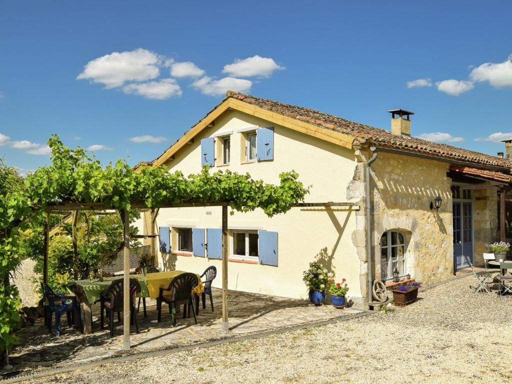 une maison avec une table et des chaises devant dans l'établissement Cottage in Dordogne with Pool & Views, à Saint-Eutrope-de-Born