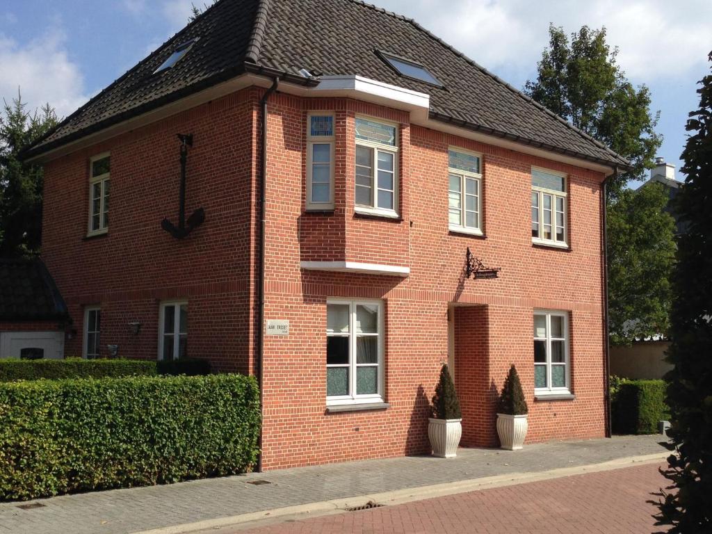 a red brick house with a clock on it at Spacious Villa in Neerpelt near Welvaart Marina in Neerpelt