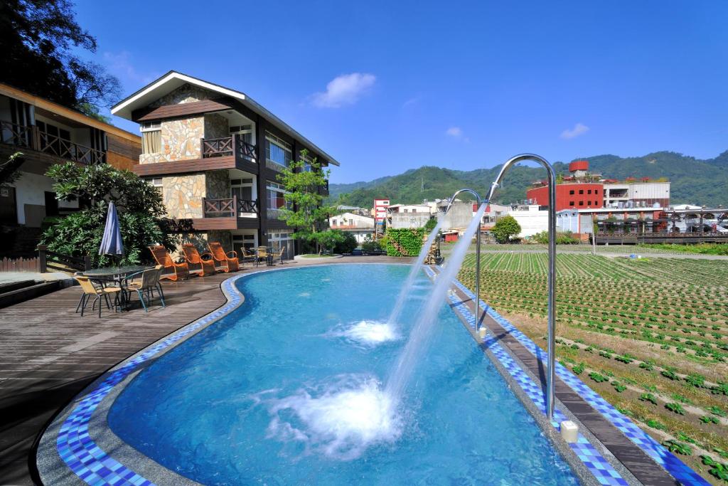 Ci Meng Rou Resort Villa في داهو: مسبح مع نافورة ماء