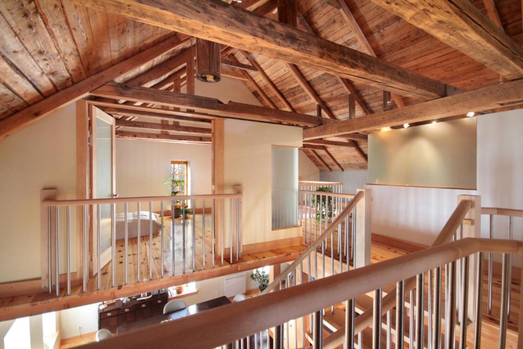 Habitación grande con techos de madera y escaleras de madera. en Cottage Jacques Cartier en Stoneham