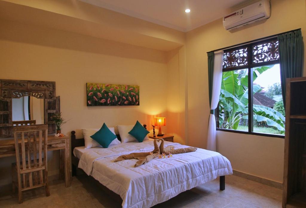 een slaapkamer met een bed en een raam bij Pondok Muwa Guest House in Ubud