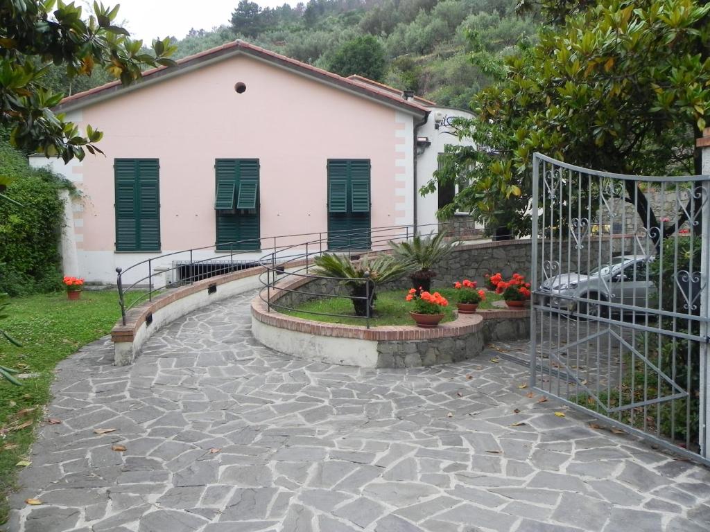 un giardino con passerella in pietra e un edificio bianco di Hotel Il Saraceno a Volastra