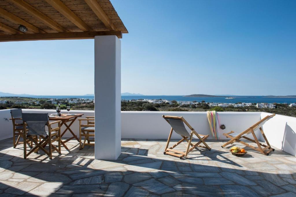 a patio with chairs and a table on a roof at Villa Theros in Aliki