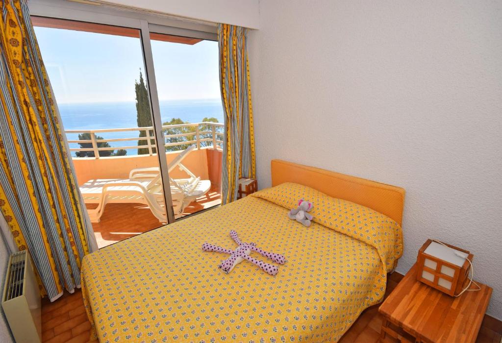 a bedroom with a bed with a cross on it at Résidence &quot;Le Golfe Bleu&quot; in Roquebrune-Cap-Martin