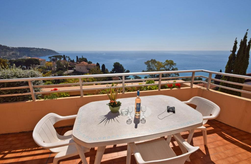 a table with a bottle of wine on a balcony at Résidence &quot;Le Golfe Bleu&quot; in Roquebrune-Cap-Martin