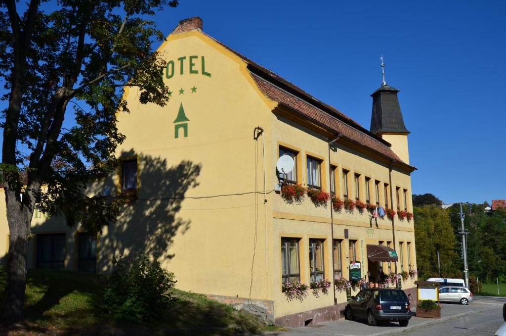 ein gelbes Gebäude mit einem Schild an der Seite in der Unterkunft Hotel U Branky in Stříbro