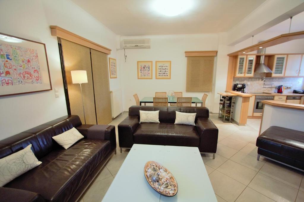 een woonkamer met leren banken en een tafel bij Niso Villas in Yírion