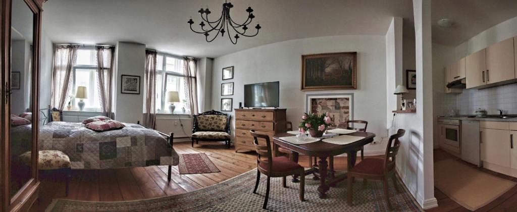 Cet appartement comprend une chambre avec un lit et une table ainsi qu'une cuisine. dans l'établissement Cafe 28 & Pension am Markt, à Wismar