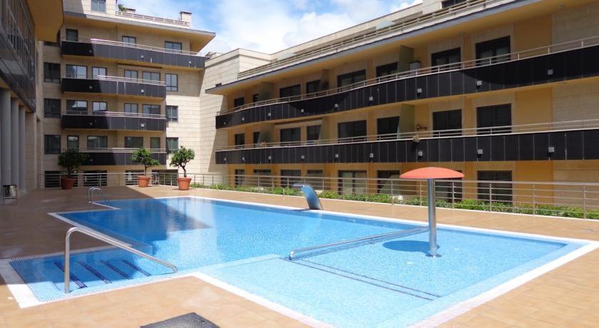 a large swimming pool in front of a building at Playa Silgar-Sanxenxo in Sanxenxo