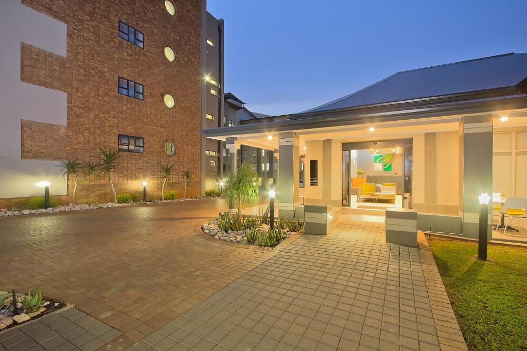 um edifício com um pátio em frente em The Park Lodge Hotel em Pretoria