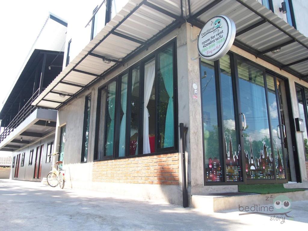 a building with windows and a sign in front of it at Bedtime Story in Mae Sai