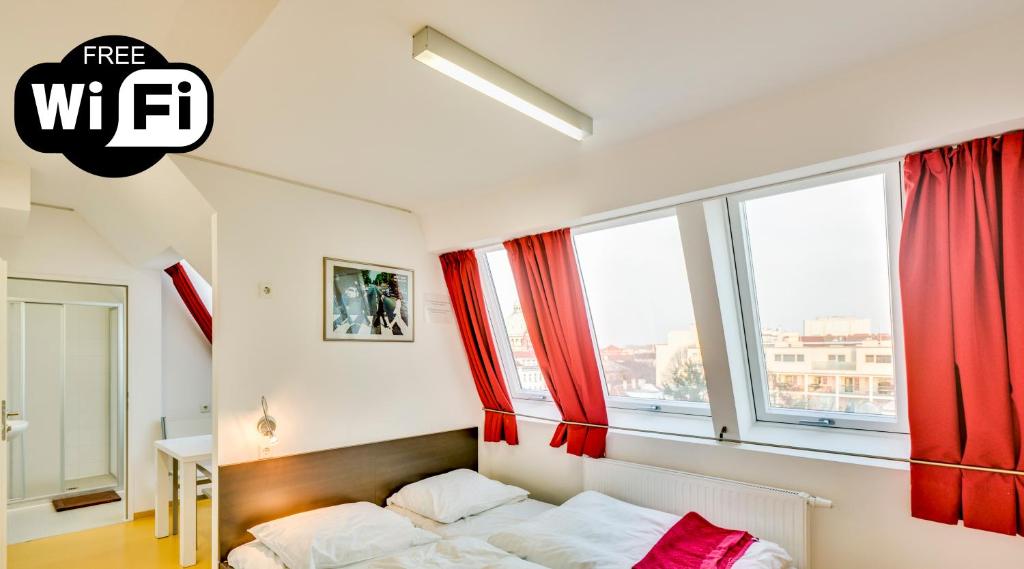 Schlafzimmer mit roten Vorhängen und einem Bett in der Unterkunft a&t Holiday Hostel in Wien