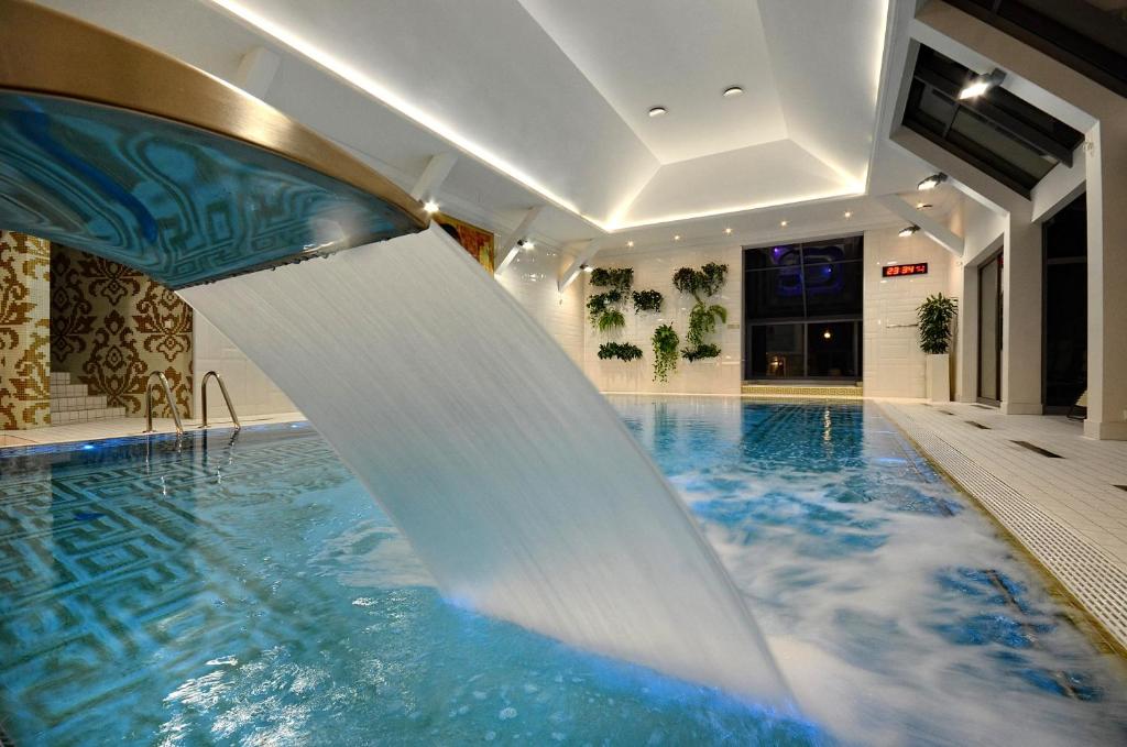 a pool with a water slide in a building at Mazowsze Medi Spa in Ustroń