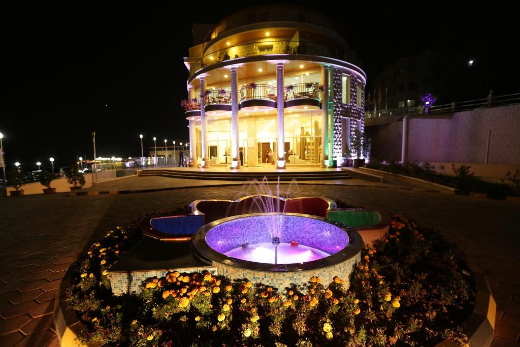 アレイにあるGolden Lili Resort & Spaの夜間の噴水のある建物